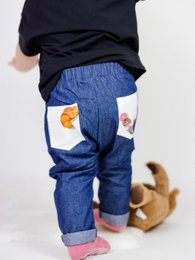 Baby denim jeans with colorful patches and pockets. Available in sizes 3-6 months to 2-3 years.