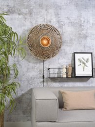 A round, woven wall lamp with a warm, glowing light source. The lamp has a natural, earthy tone that complements the modern, minimalist decor.