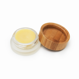 Vegan, plastic-free lip balm in a wooden container with 4 natural ingredients.