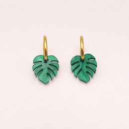 Gold hoop earrings with green monstera leaf charms, tropical plant design, statement jewelry.