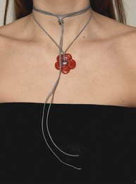  A red flower-shaped pendant necklace with a long, adjustable cord. The necklace features a simple, elegant design and is available in a variety of colors including beige, black, grey, pink, purple, chocolate, ocean green, white, mint, and khaki.