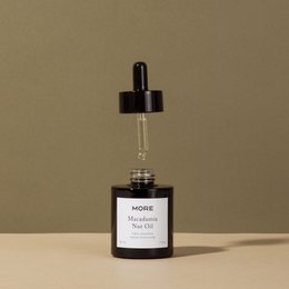 100% organic and cold-pressed macadamia oil in a glass bottle with a dropper. The oil is suitable for use as a face oil.