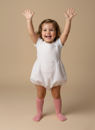  A white cotton jumpsuit for infants, featuring a checkered pattern and short sleeves. Suitable for babies aged 0-18 months.