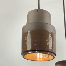 Terracotta pendant light with open design and perforated details, suitable for modern or rustic decor.