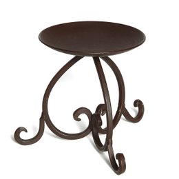Decorative iron candlestick, 11cm tall, with a round dark brown top and ornate scrolled metal base.
