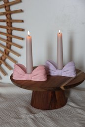  Elegant tea light holders in pastel colors with decorative bows. Available in white, pink, and lilac. Suitable for creating a cozy and inviting atmosphere.