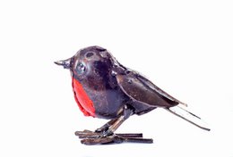  A small, realistic metal statue of a baby robin bird with a red breast and dark blue feathers.