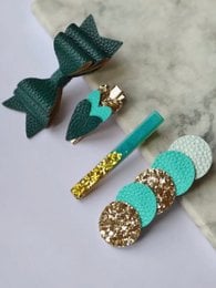 Set of 4 green hair clips with gold accents, suitable for kids. Includes a mermaid-inspired design with a bow and glitter details.