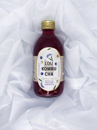 Blueberry, chamomile, and verbena kombucha in 30cl and 50cl bottles. Fermented tea beverage with a vibrant purple color.