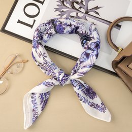  A square scarf with a floral pattern in shades of purple and white. The scarf is made of a lightweight, silky material and measures 70x70 cm.