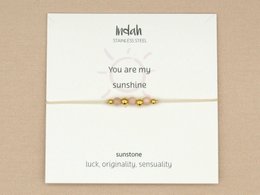 Bracelet with sunstone, silver, and gold accents. Charm bracelet with natural stones and metallic elements.