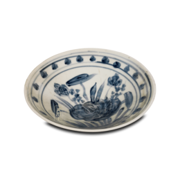 A round, shallow blue and white ceramic bowl with a lotus flower design.
