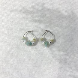 Silver hoop earrings with turquoise beads, a stylish accessory for beach waves.
