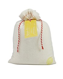 A white cloth bag containing a bath soak product from the Barr-Co Soap Shop. The bag is tied with a red and white ribbon and has a tag attached.