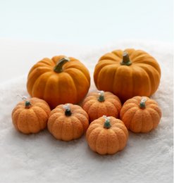 Orange and cream pumpkin-shaped pillar candles, available in multiple sizes.