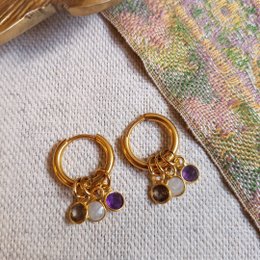Gold-toned drop earrings with purple and amber-colored beads.