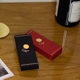 Long, red scented matches in a decorative black and red box with a gold logo.