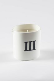  White massage candle with "III" printed on it. Cylindrical shape, made of wax material.