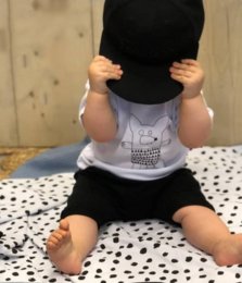 A set of 5 kids' shirts featuring wolf, bird, and mouse designs in black and white. The shirts have a simple, graphic style with animal silhouettes and minimal text.