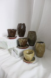 A handmade, matte gray vase with a simple, cylindrical shape.