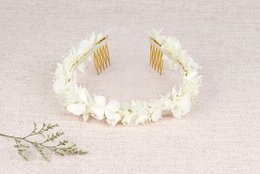 A white floral hair clip with a delicate, feminine design. The clip features small white flowers arranged in a circular shape, creating a beautiful and natural-looking accessory.