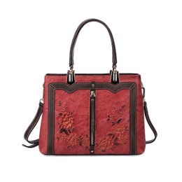  Red leather handbag with rose floral pattern, double handles, structured rectangular shape, medium size.