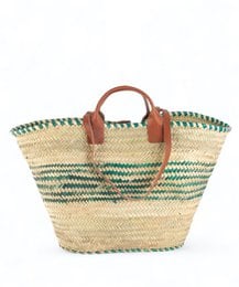 Woven straw tote bag with green and white striped pattern, featuring leather handles and trim.