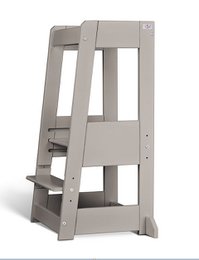 Sturdy, adjustable learning tower in beige and gray colors, designed for toddlers and young children to safely assist with kitchen tasks and activities.