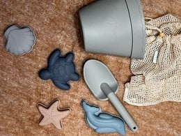 Dusty green beach set with various kids bath toys including a bucket, shovel, and starfish-shaped pieces.