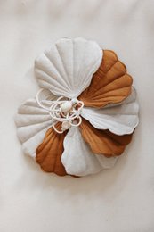 Caramel-colored linen garland with seashell accents, suitable for decorating children's spaces.