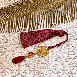 Retro-style bookmarks with sequin pompoms and tassels in various color combinations, including burgundy/gold, blue/black, and pink/purple.