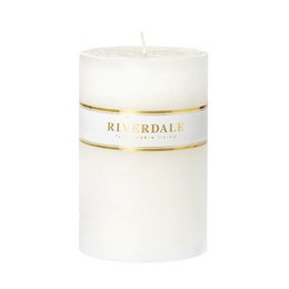  A tall, cylindrical white candle with a gold label that reads "Riverdale".