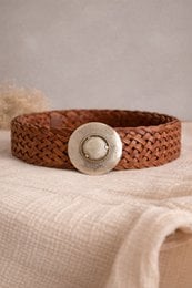 Tan woven belt with a round metal buckle.