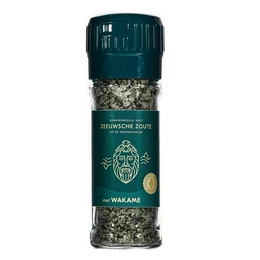 A tall, cylindrical salt mill with a clear glass body and a dark blue label featuring the Zeeuwsche Zoute logo. The mill contains a blend of salt and wakame seaweed flakes.