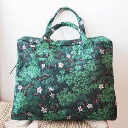 Green organic cotton weekend bag with floral botanical print, forest foliage pattern, dual handles, spacious travel tote.