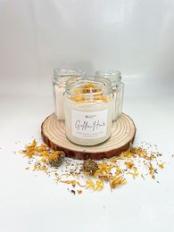 Tall, round, glass candle with golden-colored wax and a wooden base. Vanilla-scented.