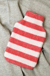  Striped hot water bottle cover in tomato red and off-white colors. Made of soft, cozy material for keeping warm.