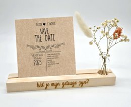 A rustic-style card holder with the text "Save the date" and a floral design. The card holder is made of wood and measures 15 cm or 20 cm in size. It is suitable for wedding invitations or announcements.