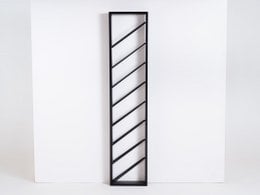 A modern, minimalist wine rack with a sleek black metal frame and diagonal shelves to hold multiple wine bottles.