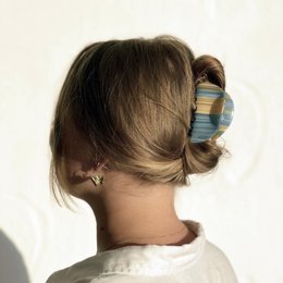 Pastel-colored hair clip with a claw design, suitable for holding up hair in a stylish updo.