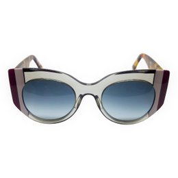 Stylish gray and burgundy striped sunglasses with a bold, oversized cat-eye frame shape.
