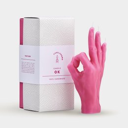 A tall, round pink candle in a gray and white box.