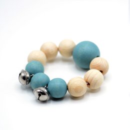  Wooden rattle with blue, natural, and pink beads. Spherical shape with metal bells for auditory stimulation. Suitable for babies and toddlers.