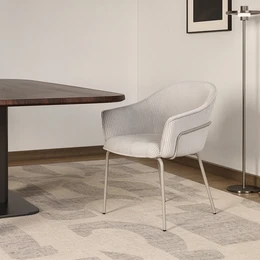  Cream velvet dining chair with curved backrest, metal legs, modern minimalist design, comfortable seating.