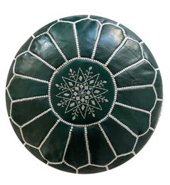 A round, green Moroccan leather pouf with a decorative pattern.