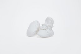 Soft, white baby shoes with a round, cushioned design for comfort and support.