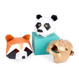 Colorful geometric animal masks in the shape of a panda, raccoon, and lion. The masks appear to be made of paper or cardboard and have a playful, artistic design.