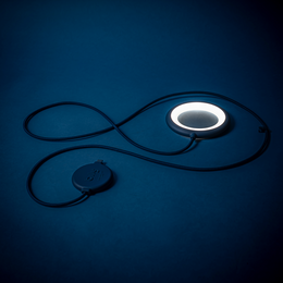 Minimalist, portable desk lamp with circular design in blue, grey, and olive green color variants.
