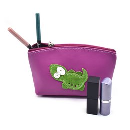  A handmade full grain leather makeup bag in a warm brown color, featuring a cute raccoon design applique.