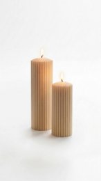  Ribbed pillar candles, tall cylindrical shape, natural beige wax, textured vertical grooves, two-piece set, warm neutral color.